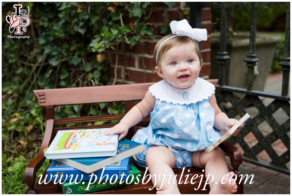 Baby girl on bench with books